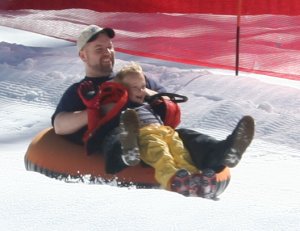 Leon and Tre tubing in the snow
